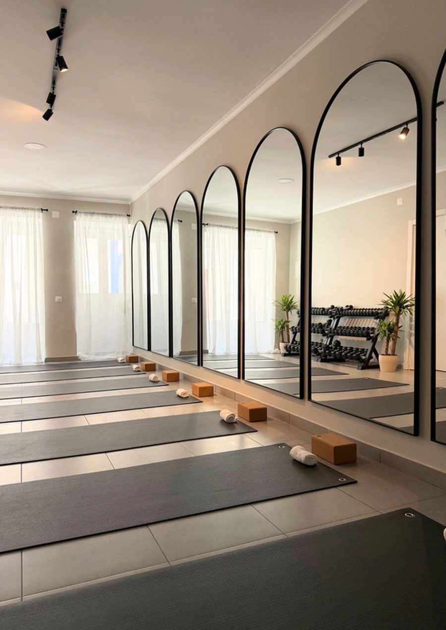 The Movement Studio in Alcácer do Sal — arched mirrors, mats laid out and weights along the wall